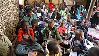 طلاب سودانيون غادروا السودان خلال الحرب الأهلية يستمعون إلى معلمهم في مدرسة للاجئين تضم نحو 73 طفلاً، في تاجوراء، شرق طرابلس، ليبيا، الاثنين 18 مايو 2026.