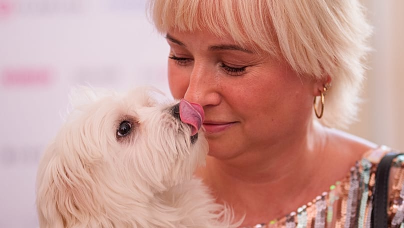 Il cane Charlotte condivide un momento di tenerezza con una donna alla cerimonia di consegna del premio Palm Dog a Cannes, nel sud della Francia, 22 maggio 2026