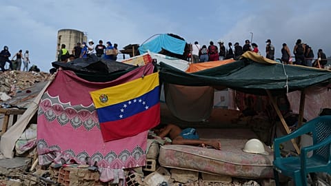 A young man sleeps while rescue teams continue to search through the rubble after the earthquakes in La Guaira.