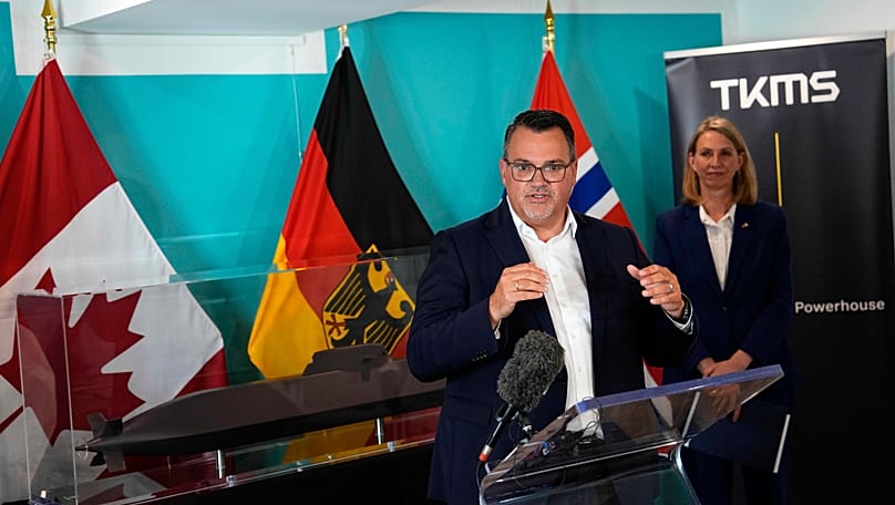 TKMS-Vorstandschef Oliver Burkhard spricht am 6. Juli 2026 bei einer Pressekonferenz in Ottawa; rechts hört die deutsche Botschafterin in Kanada, Tjorven Bellmann, zu.