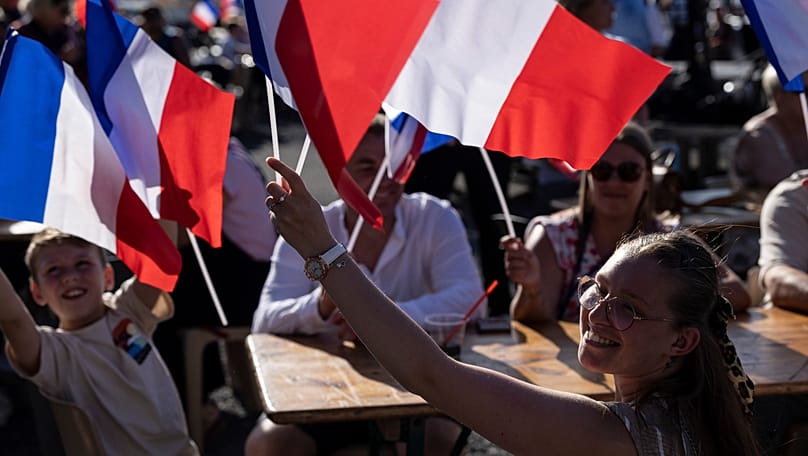 People wave French flags during a rally attended by far-right party National Rally president Jordan Bardella and far-right leader Marine Le Pen in Lievin, 4 July, 2026