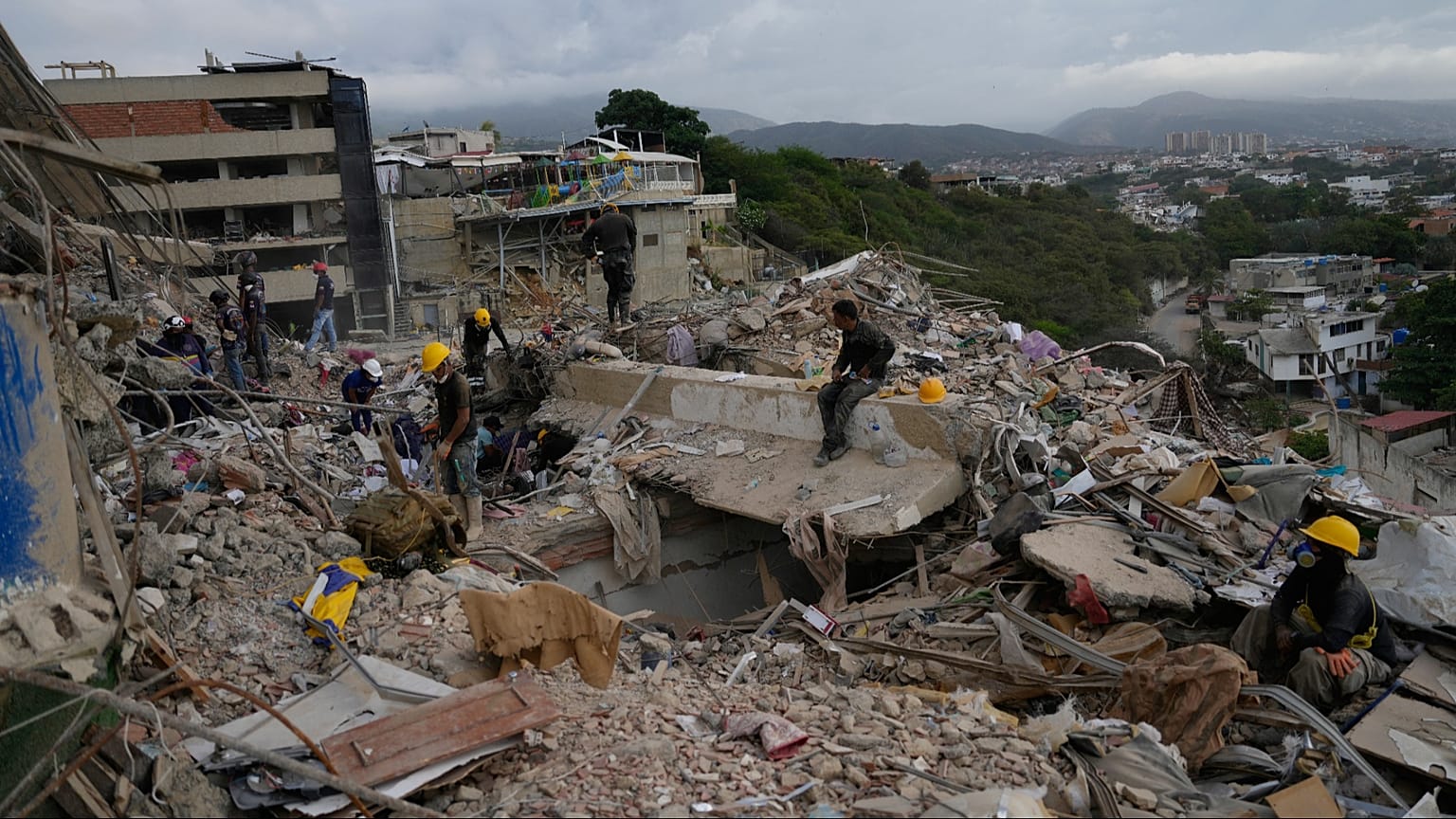 Los equipos de rescate buscan entre los escombros de un edificio derrumbado durante los terremotos en La Guaira, Venezuela, el lunes 6 de julio de 2026.