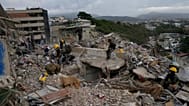 Los equipos de rescate buscan entre los escombros de un edificio derrumbado durante los terremotos en La Guaira, Venezuela, el lunes 6 de julio de 2026.