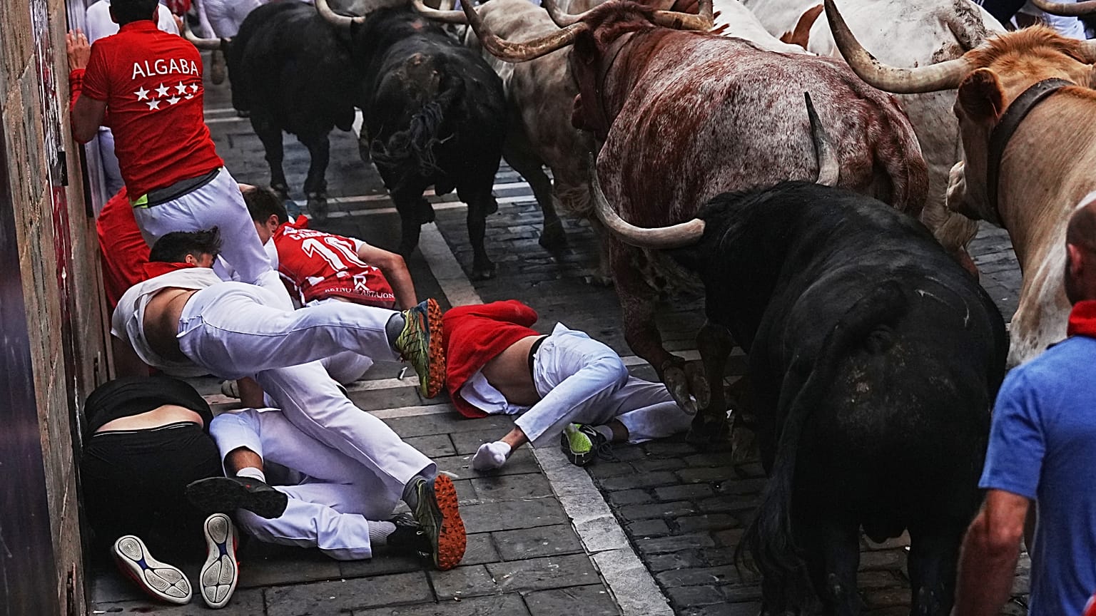 Des fêtards courent aux côtés des taureaux de combat de Fuente Ymbro lors du premier encierro des fêtes de San Fermín à Pampelune, le mardi 7 juillet 2026.