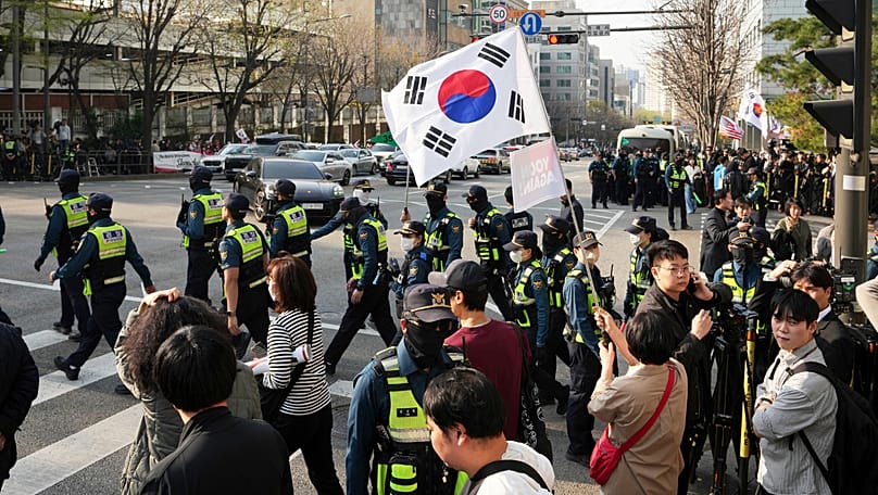 Supporters of former South Korean President Yoon Suk Yeol gather as police officers arrive near the private residence in Seoul, 11 April, 2025