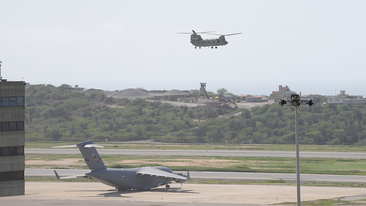 Un avión militar estadounidense permanece estacionado en la pista mientras otro despega durante las operaciones de socorro tras el terremoto en el aeropuerto de Maiquetía