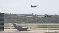 Un avión militar estadounidense permanece estacionado en la pista mientras otro despega durante las operaciones de socorro tras el terremoto en el aeropuerto de Maiquetía