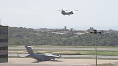 Un avión militar estadounidense permanece estacionado en la pista mientras otro despega durante las operaciones de socorro tras el terremoto en el aeropuerto de Maiquetía