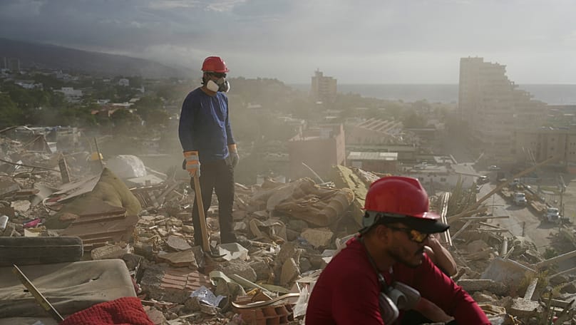 Equipos de rescate y voluntarios buscan entre los escombros de un edificio que se derrumbó durante los terremotos en La Guaira, Venezuela, el lunes 6 de julio de 2026. 