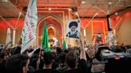 يلوح المشيعون بالأعلام الدينية الشيعية وصورة المرشد الأعلى الإيراني الراحل آية الله علي خامنئي خارج مرقد الإمام علي عشية مراسم الجنازة في النجف، العراق، الثلاثاء 7 يوليو 2026.