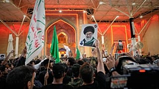 يلوح المشيعون بالأعلام الدينية الشيعية وصورة المرشد الأعلى الإيراني الراحل آية الله علي خامنئي خارج مرقد الإمام علي عشية مراسم الجنازة في النجف، العراق، الثلاثاء 7 يوليو 2026.