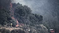 Des pompiers luttent contre un incendie de forêt près d'Ille-sur-Têt, dans le sud de la France, ce lundi 6 juillet 2026.