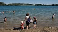 FILE: A woman and her children arrive at the Anse lake, outside Lyon, central France, during a heatwave,