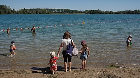 FILE: A woman and her children arrive at the Anse lake, outside Lyon, central France, during a heatwave,