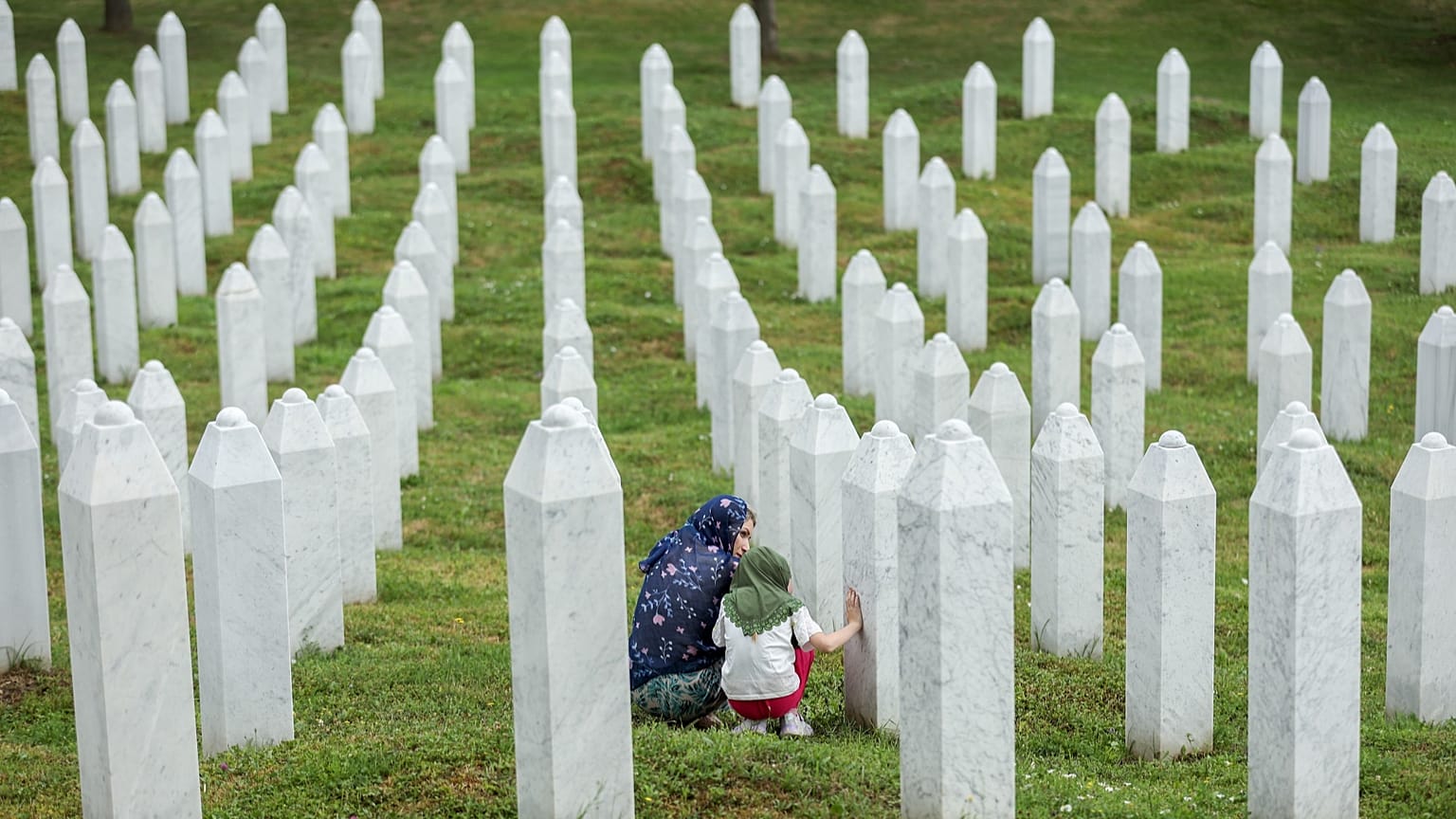 Family members mourn next to the grave of their relative at the Srebrenica Memorial Centre in Potocari, 3 July, 2026