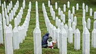 Family members mourn next to the grave of their relative at the Srebrenica Memorial Centre in Potocari, 3 July, 2026