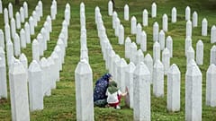 Family members mourn next to the grave of their relative at the Srebrenica Memorial Centre in Potocari, 3 July, 2026