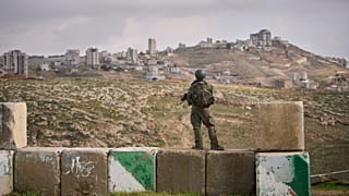 An Israeli soldier stands guard during the inauguration ceremony for the newly legalized Jewish settlement of Yatziv, near the Palestinian town of Beit Sahour, West Bank