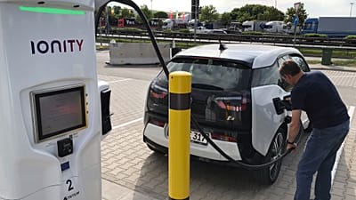A man charges his BMW electric vehicle at the rest stop Brohltal Ost at the A61 motorway in Niederzissen, Germany, May 11, 2018.