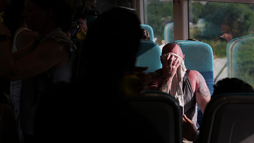 A man on a train wipes sweat from his face on a hot day in London, 24 June, 2026