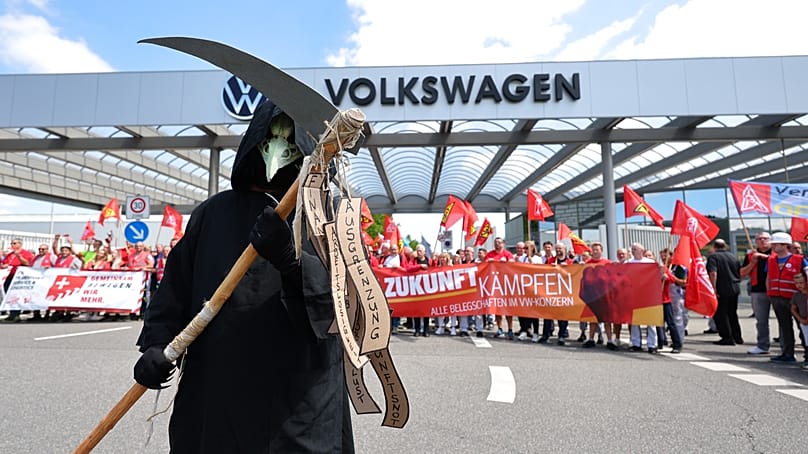 Trabalhadores protestam em frente à fábrica da Volkswagen em Zwickau, 9 de julho de 2026