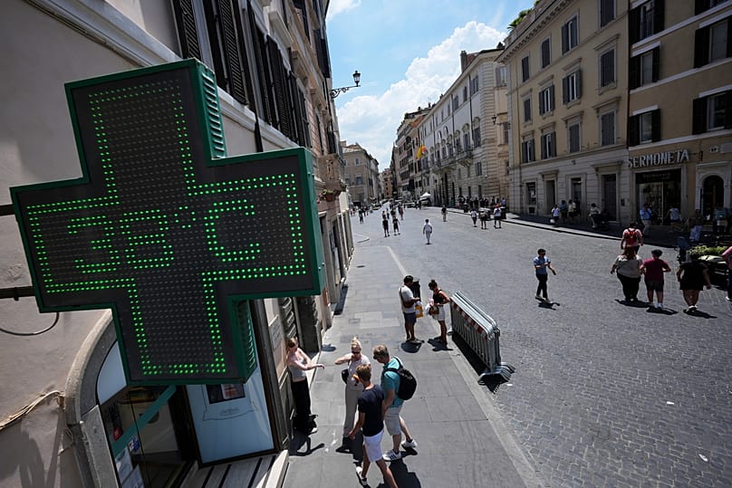 The thermometer of a drugstore shows the temperature of 38 degrees Celsius (100 degrees Fahrenheit) as temperatures reach record highs, in Rome, Wednesday, June 24, 2026. 