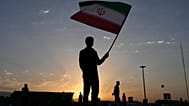 رجل يحمل العلم الإيراني مع شروق الشمس قبل جنازة المرشد الأعلى علي خامنئي في طهران، السبت 4 يوليو 2026