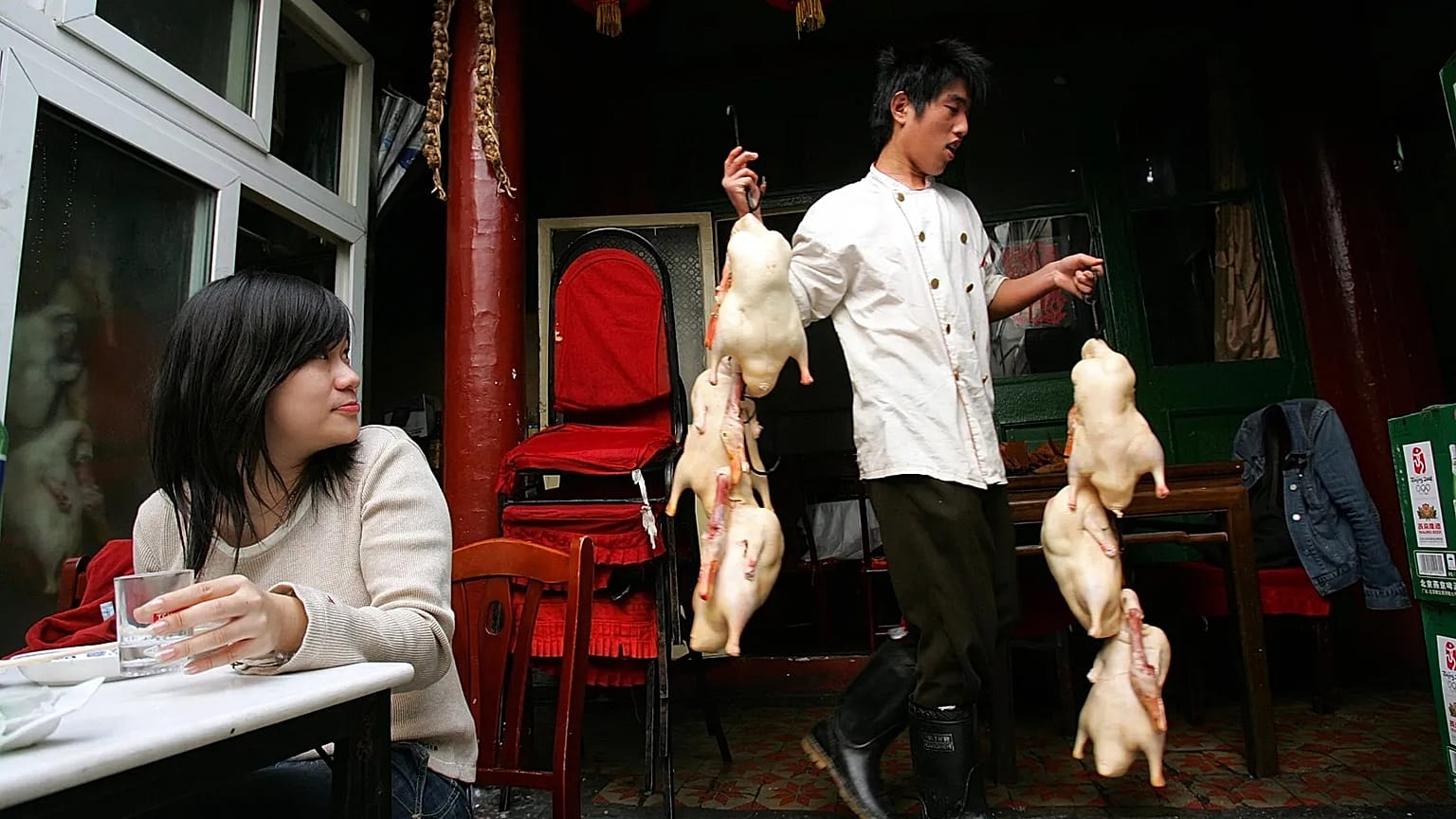 A Chinese man carries ducks to prepare in the traditional Peking style at a restaurant in a Huton in Beijing. 