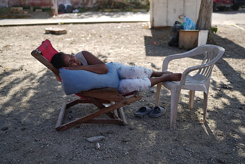 Una mujer descansa junto a unos edificios que se derrumbaron durante los terremotos en La Guaira, Venezuela, el martes 7 de julio de 2026. 