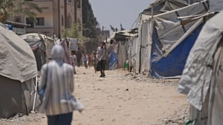 نازحون فلسطينيون يسيرون بين الخيام في دير البلح بوسط قطاع غزة، السبت 4 يوليو 2026. (AP Photo/عبد الكريم حنا)