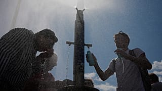 Tourists cool off at a public water fountain in Paris, 26 June, 2026