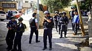 يقف عناصر من شرطة الحدود الإسرائيلية أمام منزل الفلسطيني معتز حجازي بعد إطلاق النار عليه في القدس الشرقية يوم الخميس، 30 أكتوبر/تشرين الأول 2014