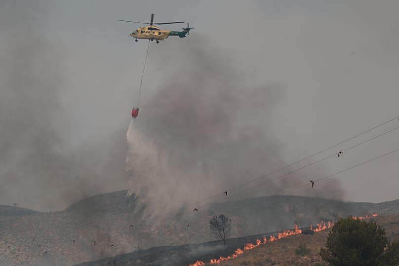 A helicopter drops water while fighting a wildfire in Los Gallardos, 10 July, 2026