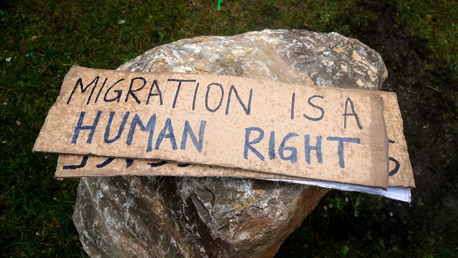 Placards are pictured as activists attempt to remove rocks placed by the townhall to avoid gatherings of migrants in Calais, 6 March, 2023