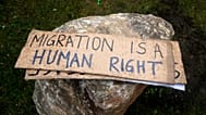 Placards are pictured as activists attempt to remove rocks placed by the townhall to avoid gatherings of migrants in Calais, 6 March, 2023