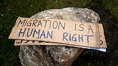 Placards are pictured as activists attempt to remove rocks placed by the townhall to avoid gatherings of migrants in Calais, 6 March, 2023