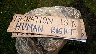 Placards are pictured as activists attempt to remove rocks placed by the townhall to avoid gatherings of migrants in Calais, 6 March, 2023
