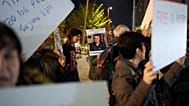  امرأة تحمل لافتة عليها صورة الدكتور الفلسطيني حسام أبو صفية خلال احتجاج يطالب بالإفراج عنه أمام مكاتب الشاباك في تل أبيب، إسرائيل، 1 يناير 2025.