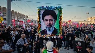 رجل يحمل صورة المرشد الأعلى الإيراني الجديد مجتبى خامنئي في مسجد الإمام الخميني مصلى الكبير خلال مراسم جنازة المرشد الأعلى الإيراني المقتول آية الله علي خامنئي وأفراد عائلته