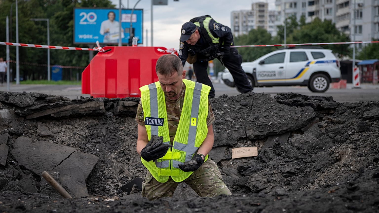 Bir bomba imha uzmanı, 11 Temmuz Cumartesi günü Kiev’in bir yerleşim bölgesine düşen Rus füzesinin isabet ettiği noktayı inceliyor.