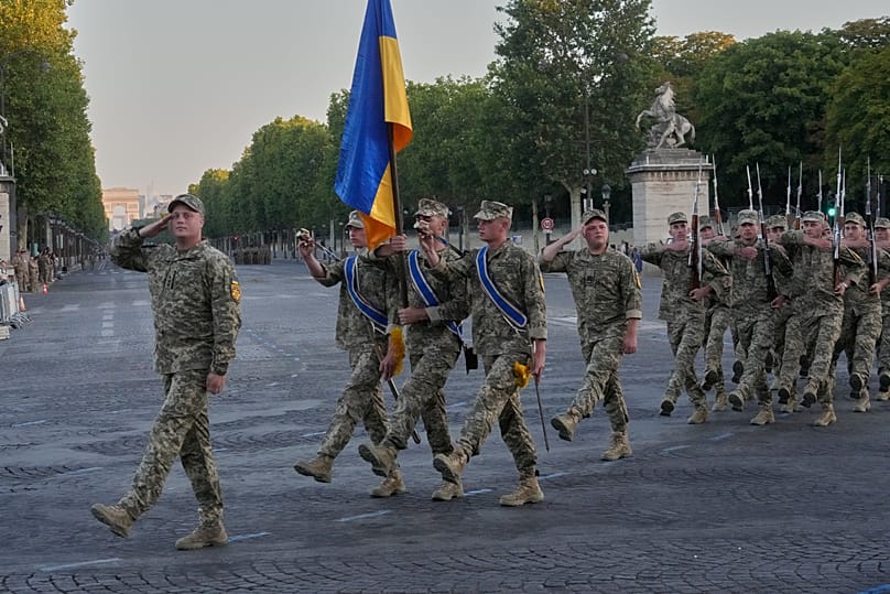 Ukranian soldiers march with their national flag during a rehearsal for the upcoming Bastille Day parade, Thursday, July 9, 2026 on the Champs-Elysees avenue in Paris.