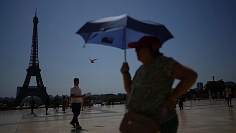 People walk at Trocadero plaza near the Eiffel Tower during a heat wave July 2, 2025, in Paris.
