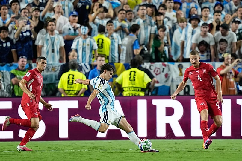 Argentina's Julian Alvarez (9) scores his team's second goal between Switzerland's Remo Freuler (8) and Nico Elvedi (4) during the World Cup quarterfinal match.