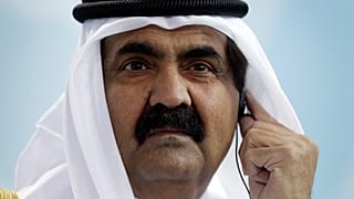 أمير قطر الشيخ حمد بن خليفة آل ثاني يرتدي سماعة ترجمة خلال مؤتمر صحفي مشترك مع المستشارة الألمانية أنجيلا ميركل بعد اجتماع في المستشارية في برلين، ألمانيا