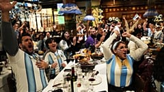 هواداران در رستورانی در بوئنوس‌آیرس مسابقه فوتبال یک‌چهارم نهایی جام جهانی بین آرژانتین و سوئیس را تماشا می‌کنند