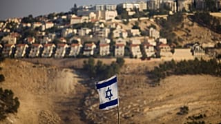 an Israeli flag is seen in front of the West Bank Jewish settlement of Maaleh Adumim on the outskirts of Jerusalem