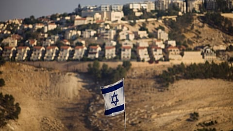an Israeli flag is seen in front of the West Bank Jewish settlement of Maaleh Adumim on the outskirts of Jerusalem