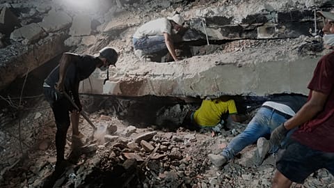 Núñez ailesi, Venezuela'nın La Guaira kentinde depremler nedeniyle yıkılan bir binanın enkazı arasında bir yakınını arıyor, 9 Temmuz 2026 Perşembe.