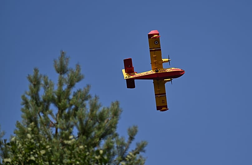 A water bomber flies over the historic Fontainebleau forest region, 13 July, 2026