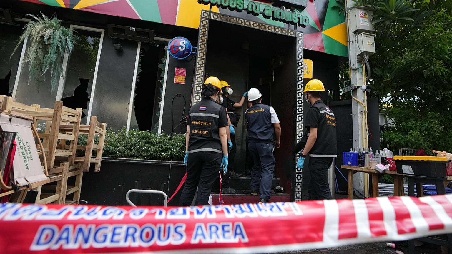 Forensic police officers inspect the site of a fire in Bangkok, 13 July, 2026